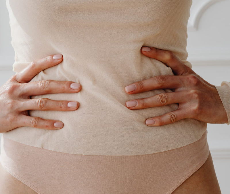 Woman holding stomach abdominal pain from IBS symptoms